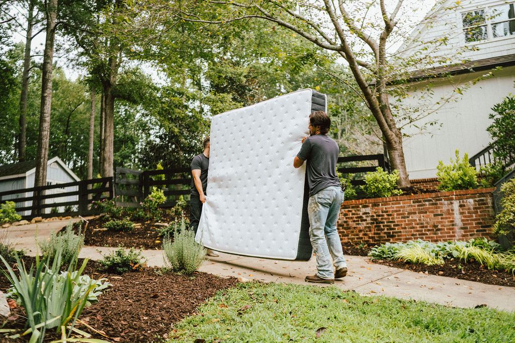Loaders carrying a mattress out for curbside pickup, the kind of removal we run daily in Milton