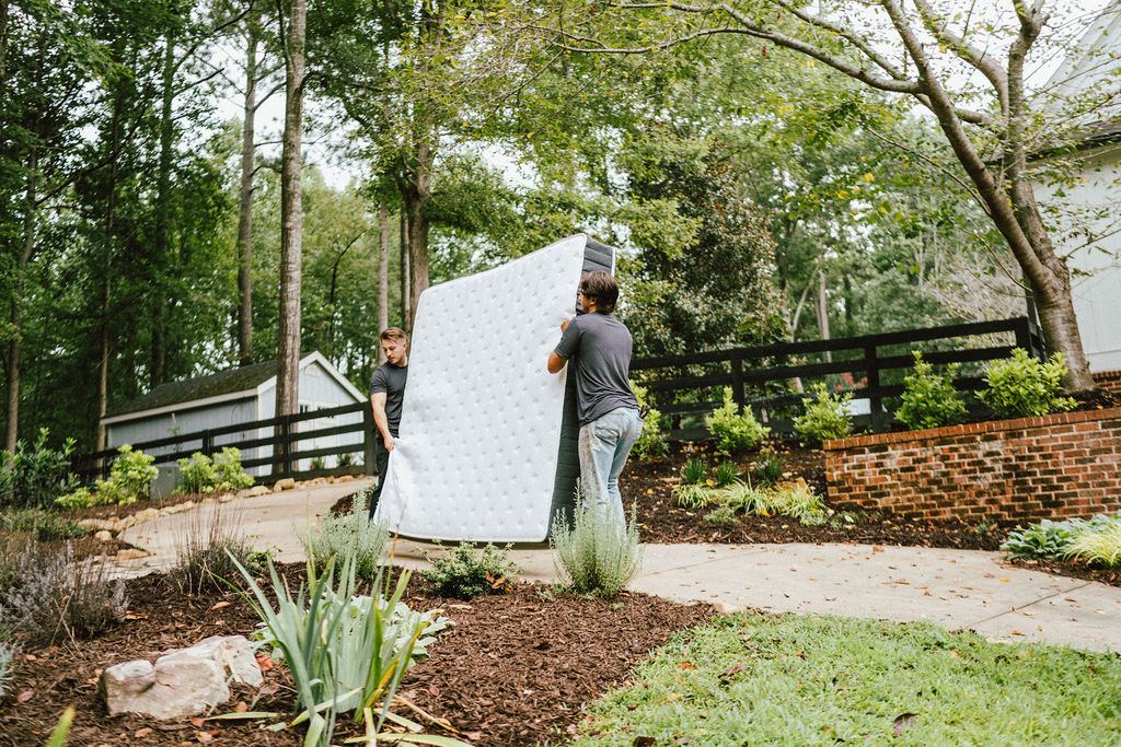 Loaders carrying a mattress out for curbside pickup, the kind of removal we run daily in Roswell