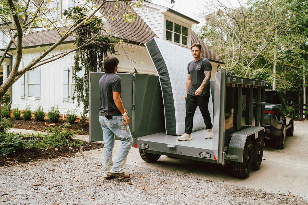 Two JRP Loaders hauling a mattress out to the LoadUp trailer at a residential pickup